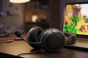 Игровая гарнитура с микрофоном рядом с ноутбуком на рабочем столе